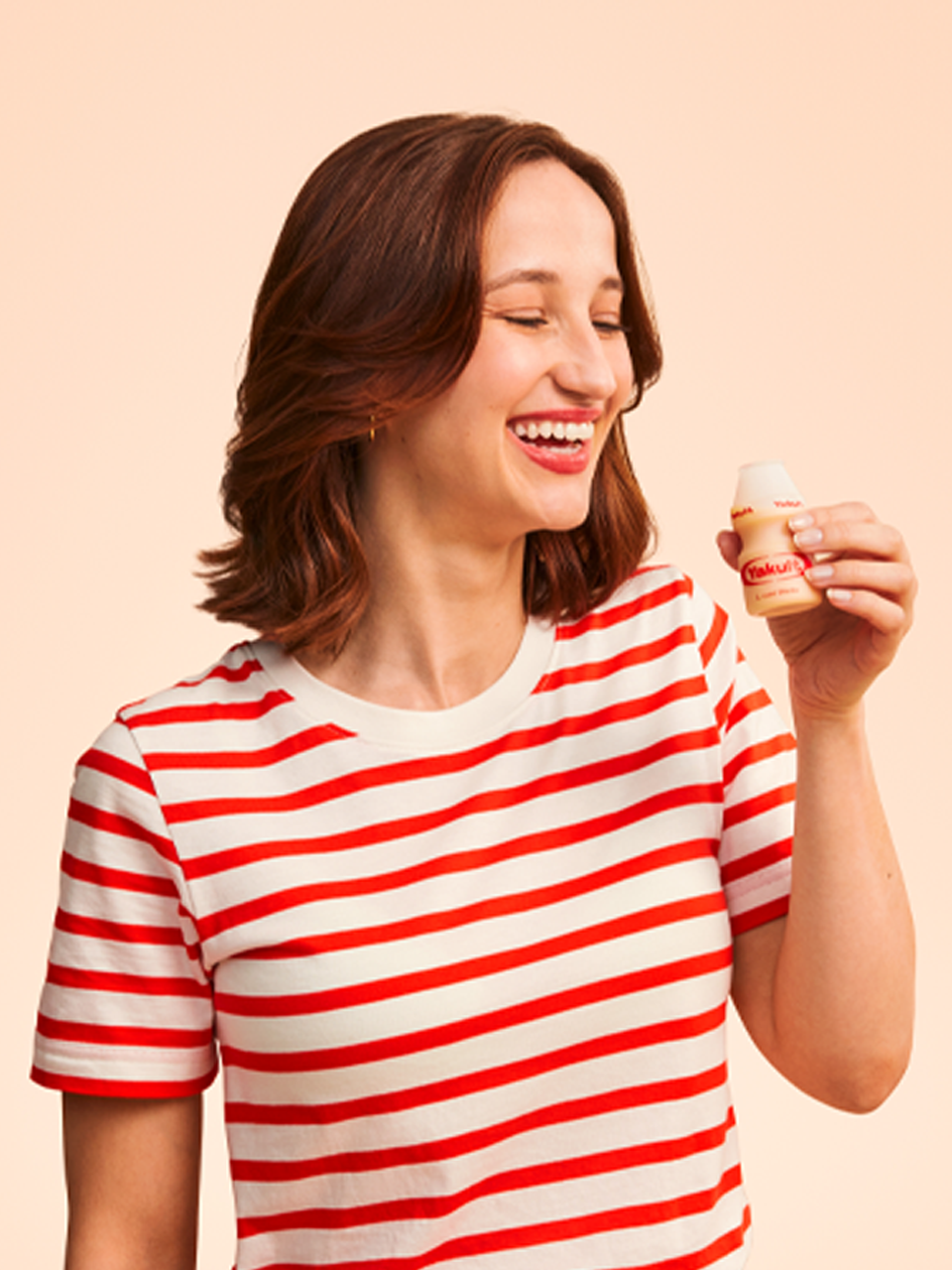 Yakult dame uit de Yakult commercial met Yakult flesje in de hand.
